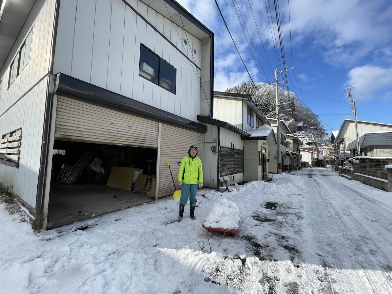 秋田県鹿角市のカーオーディオ作業用ガレージ前で除雪を行い、新たな専門ショップ「湯けむりガレージ」始動の様子。